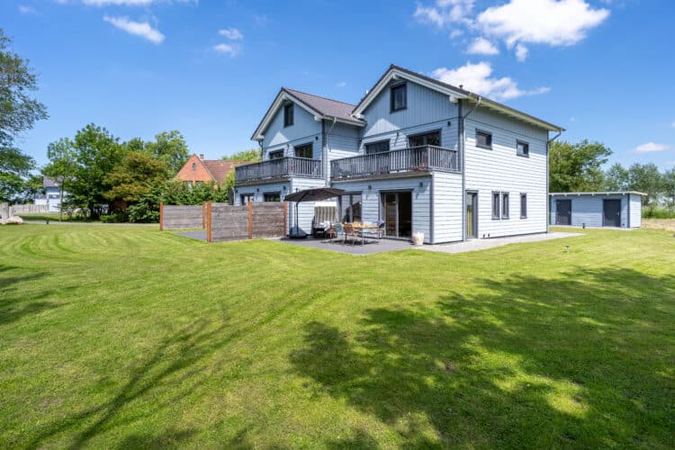 ein Haus mit einem Rasen und einem Zaun