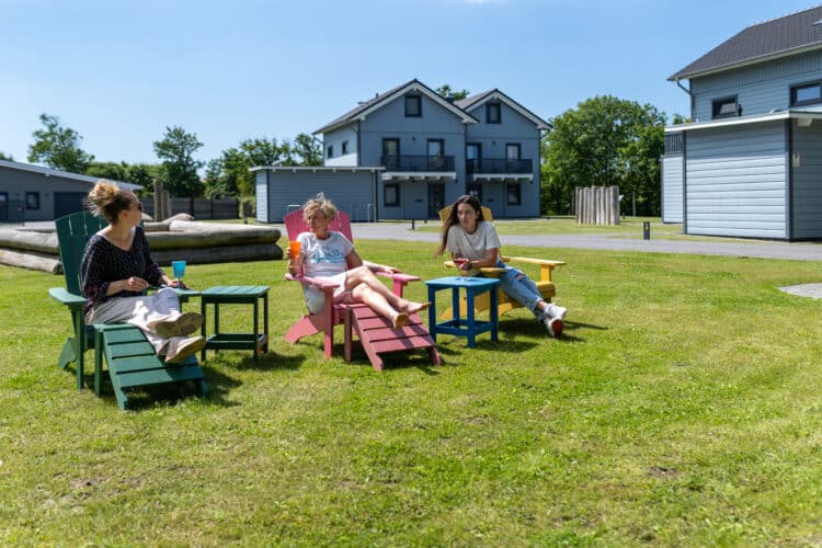 eine Gruppe von Menschen, die draußen auf Stühlen sitzen