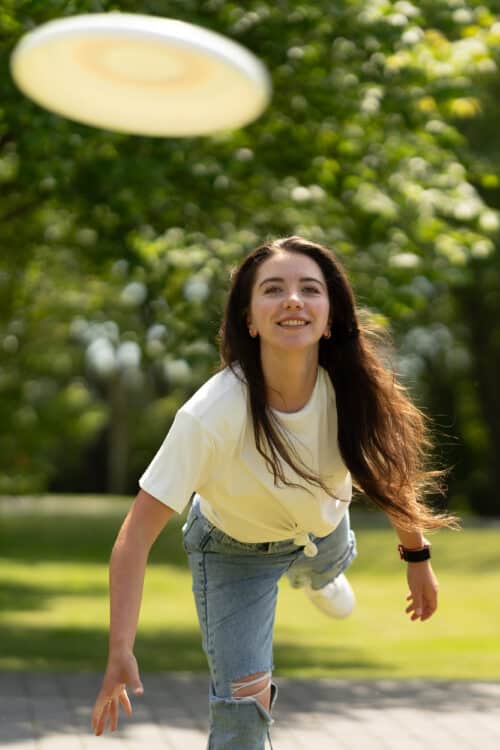 eine Frau mit langen Haaren und einem weißen Frisbee