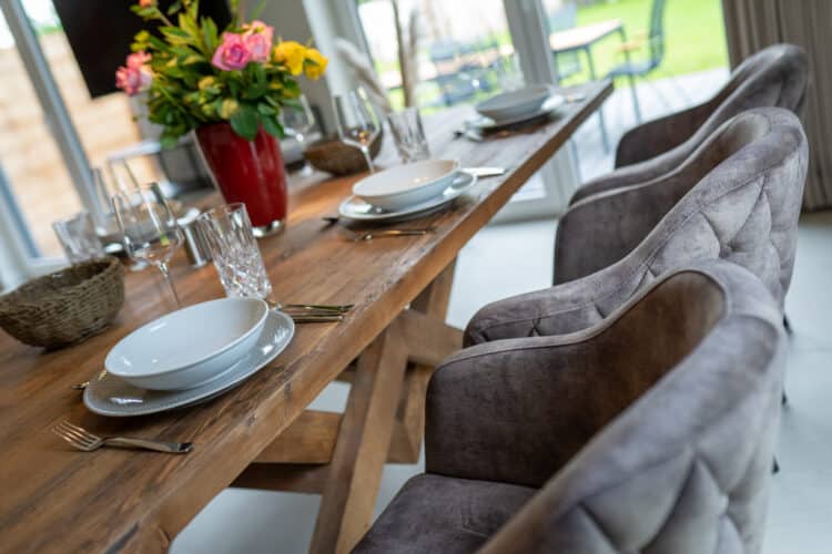 ein Tisch mit Tellern, Gläsern und einer Blumenvase